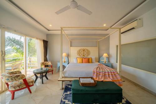 a bedroom with a bed and a large window at Perfectstayz Koko Maya 5 mins walk to beach in Morjim