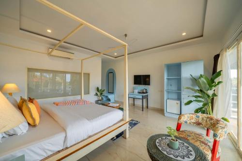 a bedroom with a large bed and a desk at Perfectstayz Koko Maya 5 mins walk to beach in Morjim