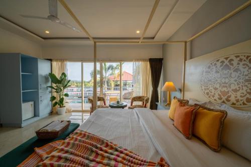 a bedroom with a large bed and a large window at Perfectstayz Koko Maya 5 mins walk to beach in Morjim