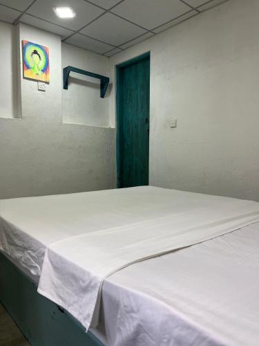 a large white bed in a room with a blue door at Cactus Arugambay in Arugam Bay