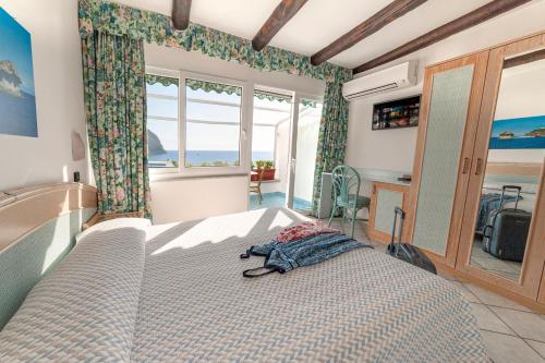a bedroom with a large bed and a large window at Appartamenti Casa del Sole in Ischia