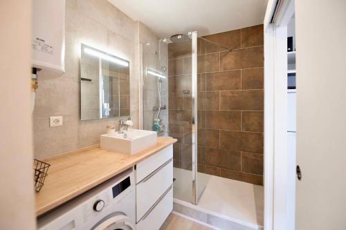 a bathroom with a sink and a shower at Residence du Centre Joli studio rénové avec coin nuit terrasse et parking privé in Capbreton