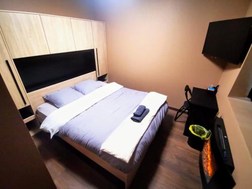 une chambre avec un grand lit avec une grande tête de lit dans l'établissement Appart'Hôtel Le Phoenix, à Montbéliard