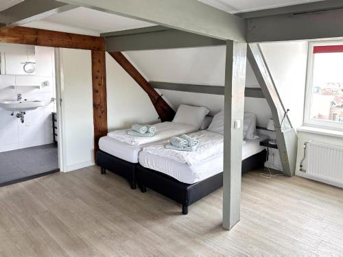 a bedroom with two beds and a sink at Huis van Egmond aan Zee in Egmond aan Zee