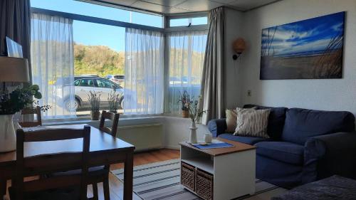 a living room with a blue couch and a table at Torenlicht in Egmond aan Zee