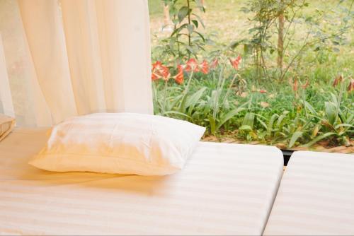 a pillow sitting on a table next to a window at Căn Bighomie in Sóc Sơn