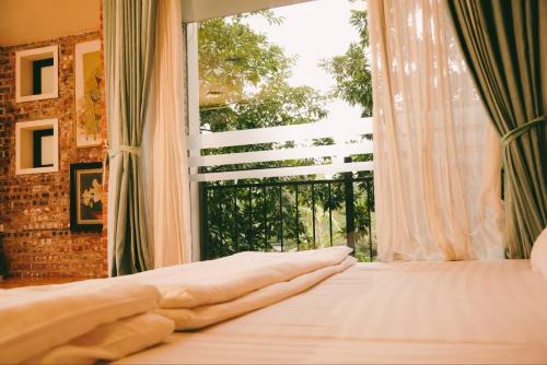 a bedroom with a bed and a large window at Căn Bighomie in Sóc Sơn