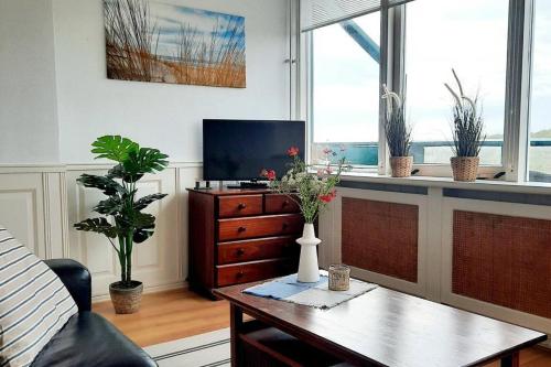 a living room with a table and a tv at Torenlicht in Egmond aan Zee