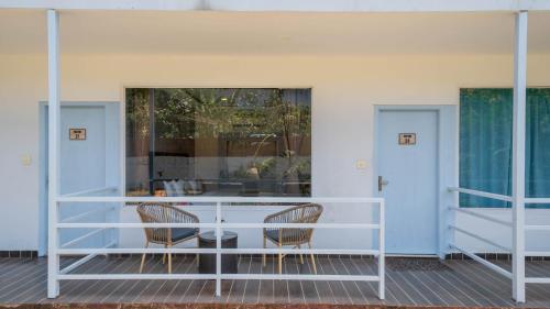a porch with two chairs and a table at Perfectstayz Koko Maya 5 mins walk to beach in Morjim