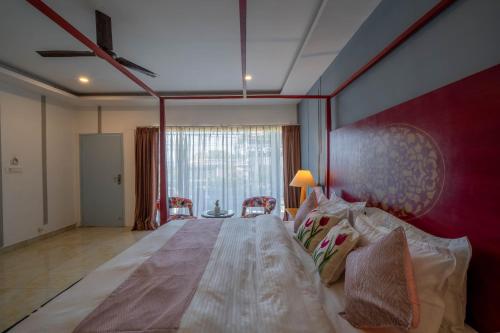 a large bed in a room with a large window at Perfectstayz Koko Maya 5 mins walk to beach in Morjim