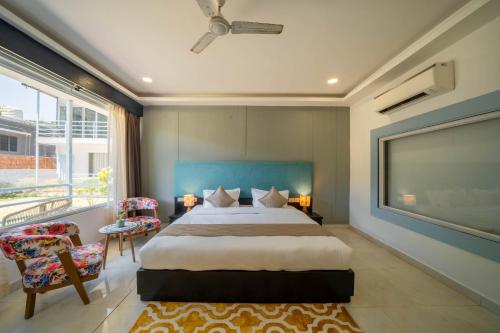 a bedroom with a large bed and a large window at Perfectstayz Koko Maya 5 mins walk to beach in Morjim