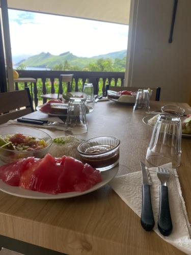a wooden table with a plate of food on it at HEIIKIANI Sweet Home in Nuku Hiva