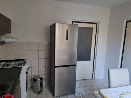 a stainless steel refrigerator in a kitchen with a door at Modern urban loft apartment in Opava