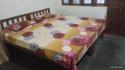 a bed with red and blue roses on it at PandeyGuestHouse in Almora