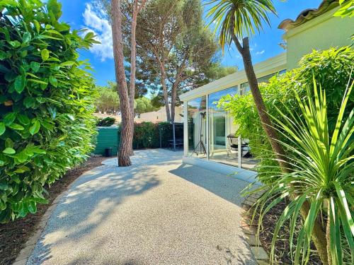une maison avec un palmier et une passerelle dans l'établissement L'Écrin de la Pinède, Villa, Piscine,Climatisation, au Cap d'Agde