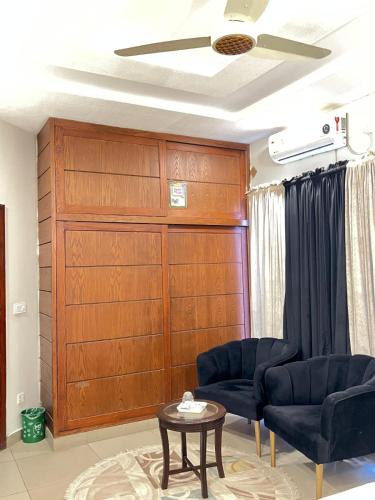 a living room with two chairs and a wooden wall at New star lodge in Dargai