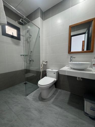 a bathroom with a toilet and a sink and a shower at Hotel Phạm Gia Phan Thiết in Phan Thiet