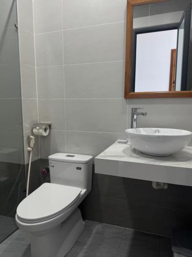 a bathroom with a white toilet and a sink at Hotel Phạm Gia Phan Thiết in Phan Thiet