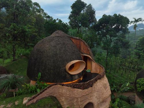 a tree stump with a boat in a forest at Toroland Munnar in Viripara