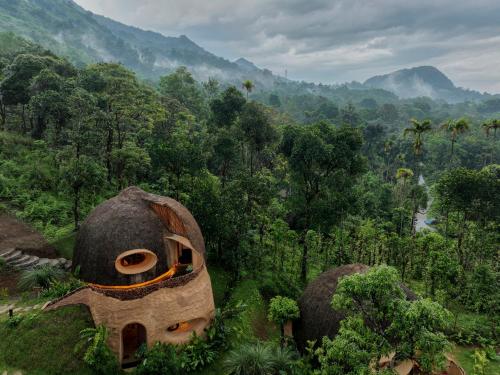 an aerial view of a forest with two mushroom houses at Toroland Munnar in Viripara