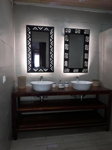 a bathroom with two sinks and a mirror at La Creole APT 09 in Toamasina