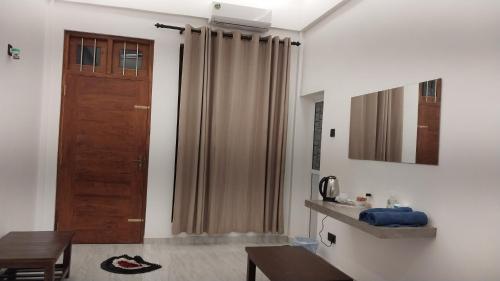 a living room with a wooden door and a table at 102 1B boossa galle in Nikawatawana