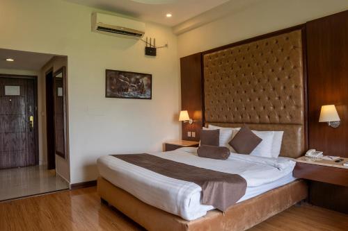a bedroom with a large bed with a large headboard at Legend Hotel Islamabad in Islamabad