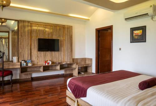 a bedroom with a bed and a desk and a television at Legend Hotel Islamabad in Islamabad