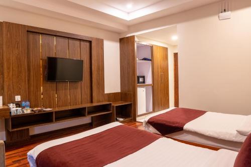 a hotel room with two beds and a flat screen tv at Legend Hotel Islamabad in Islamabad