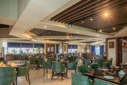 a restaurant with tables and chairs in a room at Legend Hotel Islamabad in Islamabad