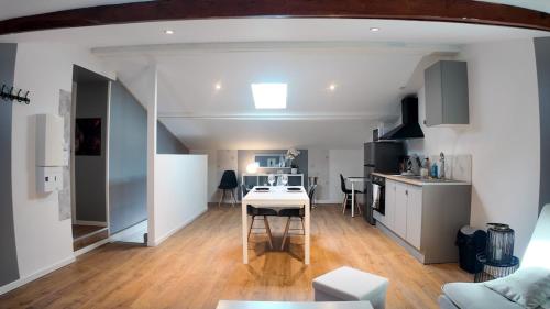 une cuisine et un salon avec une table dans une pièce dans l'établissement COSY APPARTEMENT 1 CHAMBRE l Netflix l Terrasse, à Castres