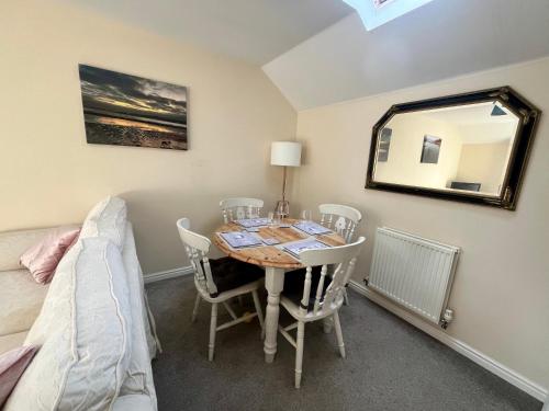 a dining room with a table and chairs and a mirror at Entire Two Bed Coach House Super King Beds Turn into singles in Countess Wear