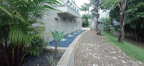 a brick walkway with a swimming pool next to a building at Flat Aconchegante - Park Veredas 312 in Rio Quente