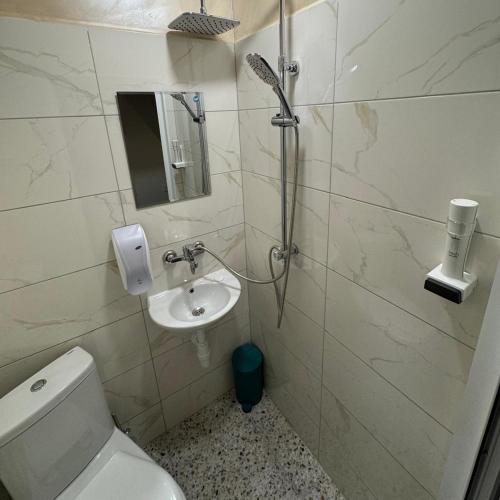 a bathroom with a toilet and a sink at Hotel Ticha in Shumen