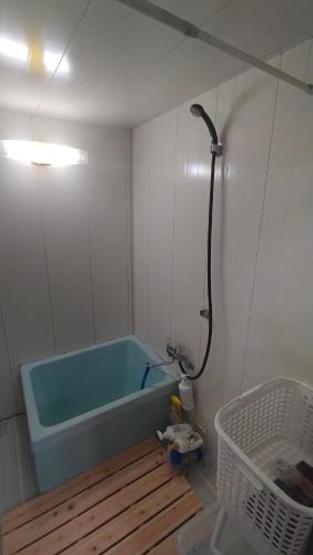 a bathroom with a blue bath tub in a room at 一棟貸しおおふなと長月 Vacation Rental Ofunato-Nagatsuki in Gero