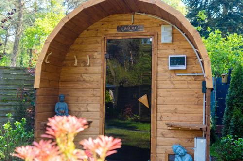 a wooden shed with a door in a garden at Ferienhaus Zissi in Wegberg