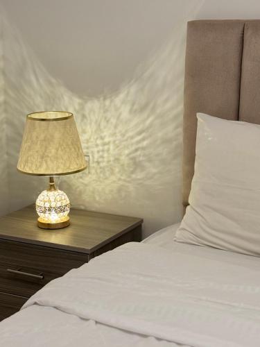 a lamp on a table next to a bed at Nabateans Home Hotel in Wadi Musa