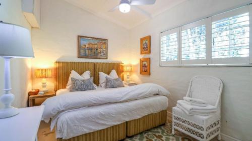 Un dormitorio con una cama y una silla dentro. en 15B Rothersand Beach House, en Plettenberg Bay