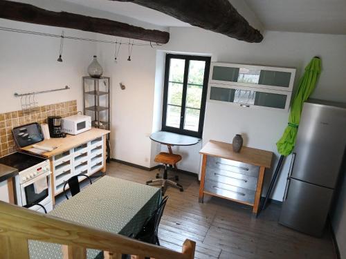 La cuisine est équipée d'une table, d'un bureau et d'un réfrigérateur. dans l'établissement Maison de ville historique dans la Haute Ville -, à Vaison-la-Romaine