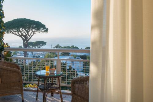 a balcony with a table and a view of the ocean at Jumeirah Capri Palace in Anacapri