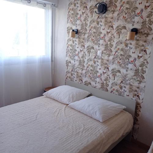 - une petite chambre avec un lit et un papier peint floral dans l'établissement Appartement cosy Sanary centre-Climatisé-Parking privé, à Sanary-sur-Mer