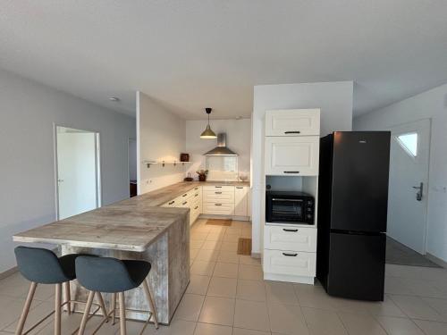 Il comprend une cuisine équipée d'un comptoir et d'un réfrigérateur noir. dans l'établissement Escapade Féline, à Mimizan-Plage