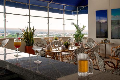 a restaurant with glasses of wine on a table at GHL Hotel Grand Villavicencio in Villavicencio