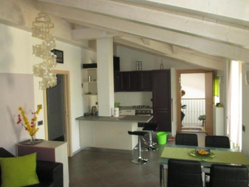 un soggiorno con tavolo e cucina di La Bella Corte ad Arco