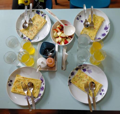 a table with plates of food and bowls of fruit at Valley Mist rooms & kitchen in Ravangla