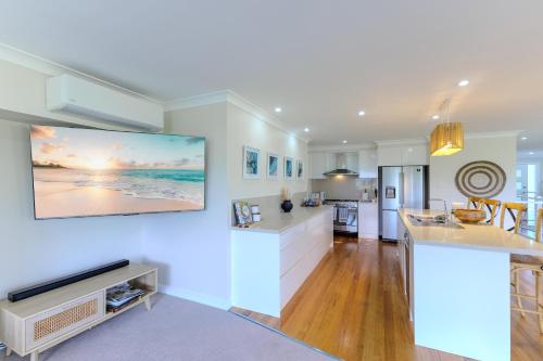 a kitchen and living room with white walls at Wave and Willow Luxury Family Retreat in Jamberoo