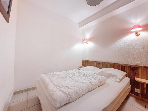 - un lit dans une chambre avec deux lumières sur le mur dans l'établissement Etoile Filante n2, à Morzine
