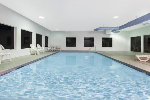 a large swimming pool with blue water in a building at Super 8 by Wyndham Lacey Olympia Area in Lacey