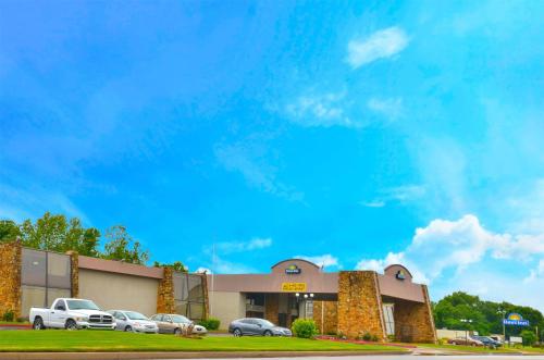 a building with cars parked in a parking lot at Days Inn by Wyndham Southern Hills/ORU in Tulsa