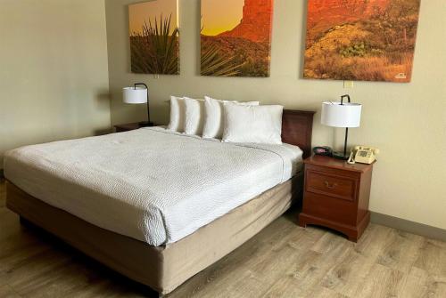 a bedroom with a bed with two lamps and a phone at Days Inn by Wyndham Kingman West in Kingman